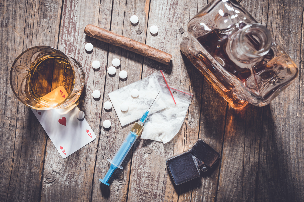 drugs and alcohol sitting on a wooden table