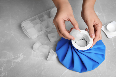 woman placing ice cubes into an ice pack