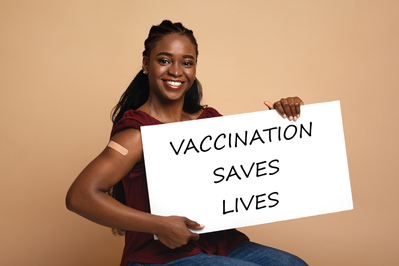 black woman holding sign that says vaccination saves lives