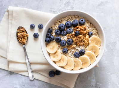 bowl of oatmeal with bananas, blueberries, and nuts